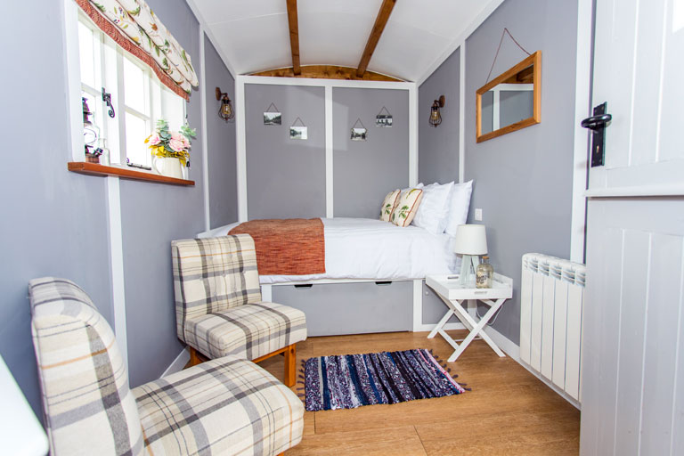 Inside Hedge Betty, showing the cosy double-bed and easy chairs
