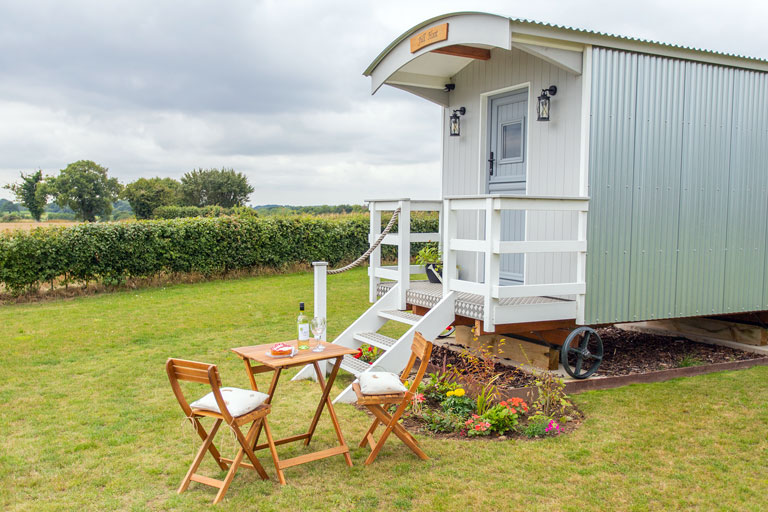 Our shepherd huts offer tranquil views across the rolling fields of Norfolk, England
